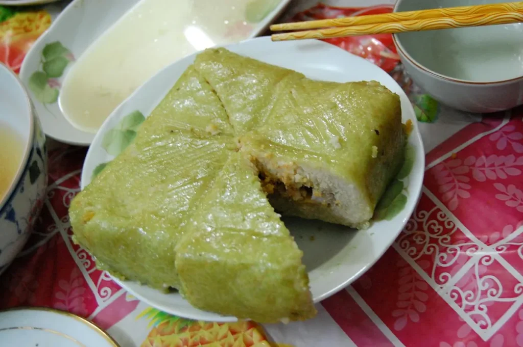 Chiếc bánh chưng đã bóc lá, cắt dở lộ nhân đậu xanh và thịt, đặt trên đĩa
