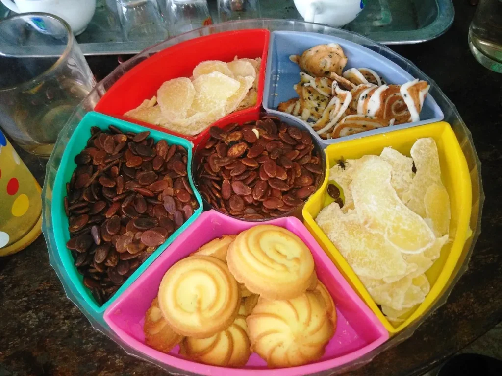 Khay mứt Tết nhiều ngăn đựng hạt dưa, bánh quy bơ và các loại mứt sấy màu vàng nhạt