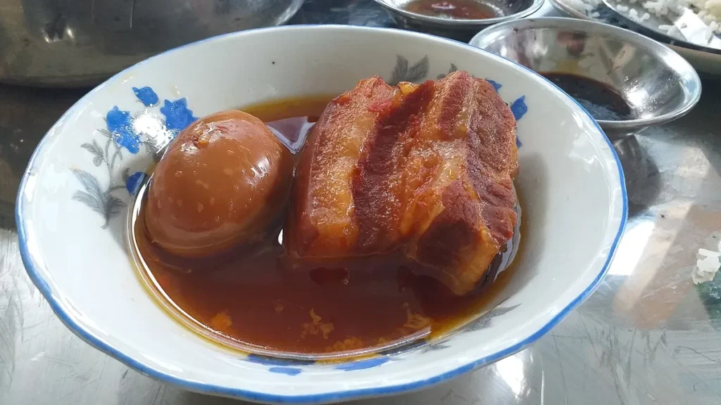 Bát thịt ba chỉ kho màu cánh gián và một quả trứng vịt kho trong nước kho sánh